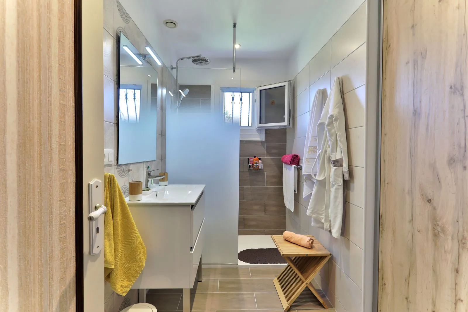 Salle de bain rénovée par Cornus à Albi avec douche de plain-pied, meuble vasque moderne et carrelage effet bois