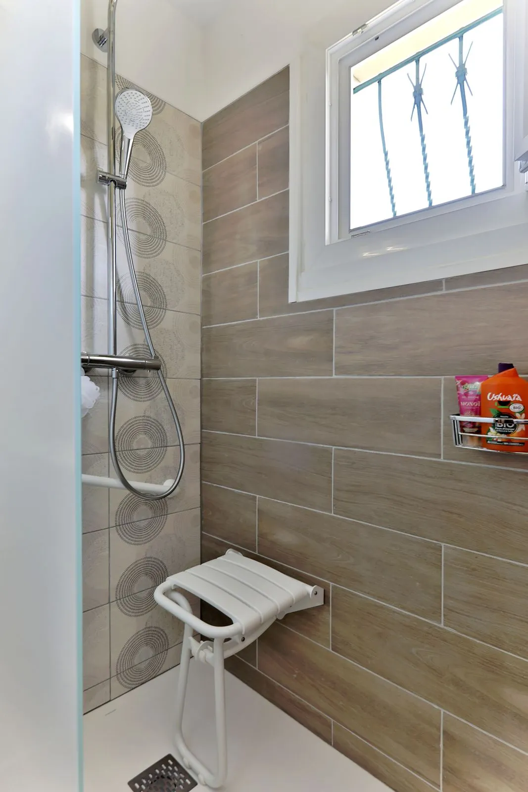 Douche accessible avec siège rabattable et barre de maintien installée par Cornus à Albi