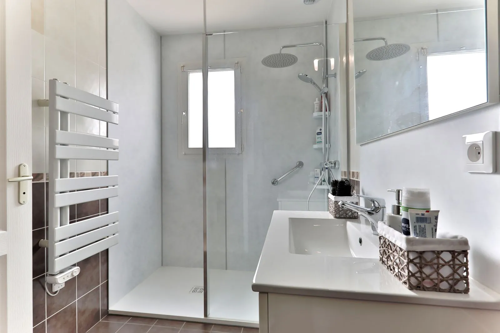Salle de bain adaptée avec douche à l'italienne, meuble vasque et sèche-serviettes, réalisation Cornus à Castres